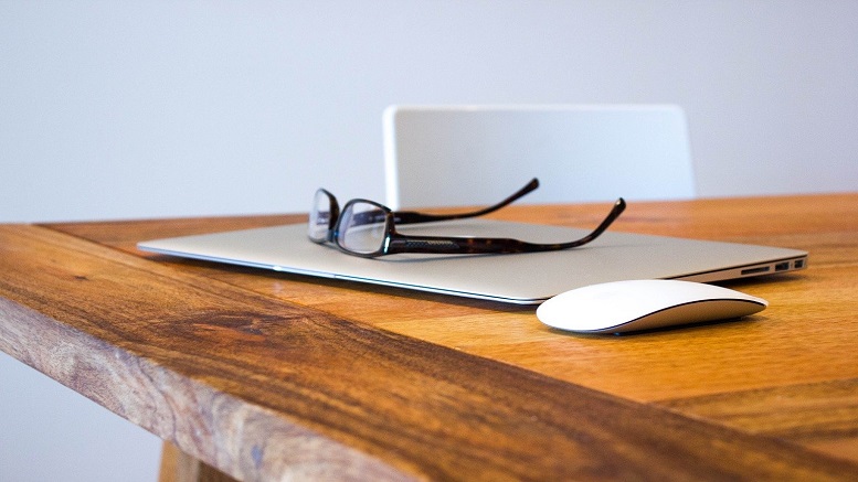 Table showing glasses and a laptop for working remotely